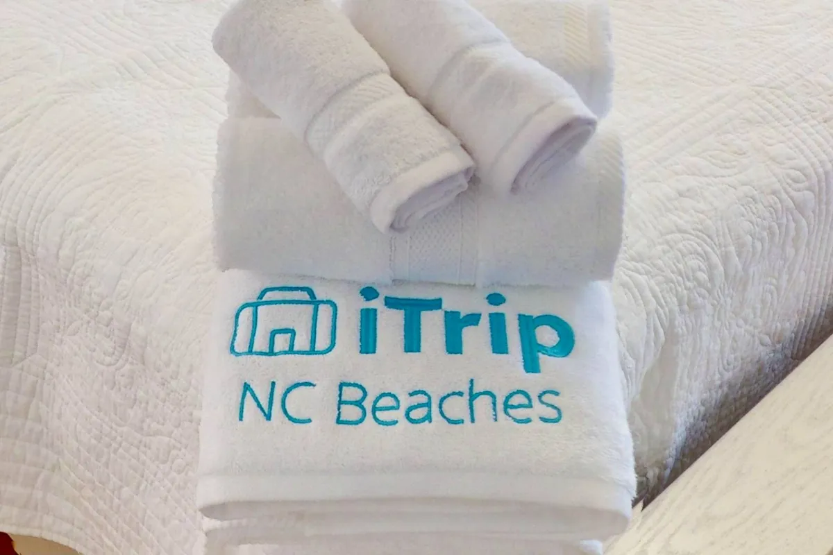 This image features neatly folded towels with an embroidered logo, set against a clean, fresh interior backdrop. The scene evokes a sense of refreshment and order, suggesting the presence of quality linens and thoughtful preparation for guests.